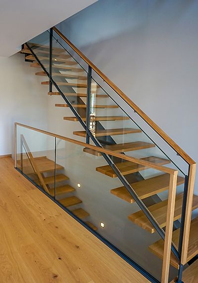 Mittelholmtreppe mit Podesten und mit frei tragenden Stufen aus Eiche, Geländer in einer Kombination aus Stahl, Glas und Holz. Brüstungsgeländer bzw. Galeriegeländer aus Verbundsicherheitsglas und Holz-Handlauf