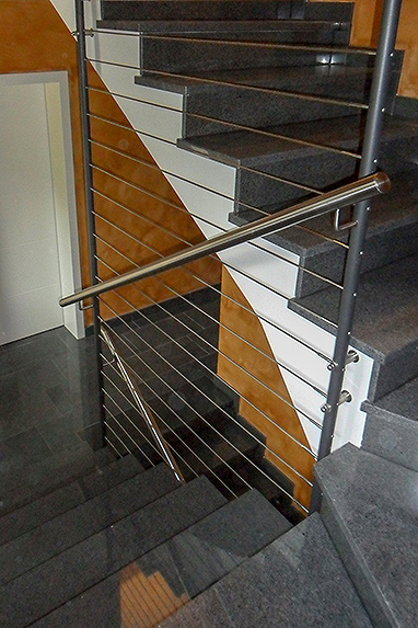 Treppengeländer im Treppenauge: durchgehende Pfosten lackiert mit horizontalen Drahtseilen aus Edelstahl.