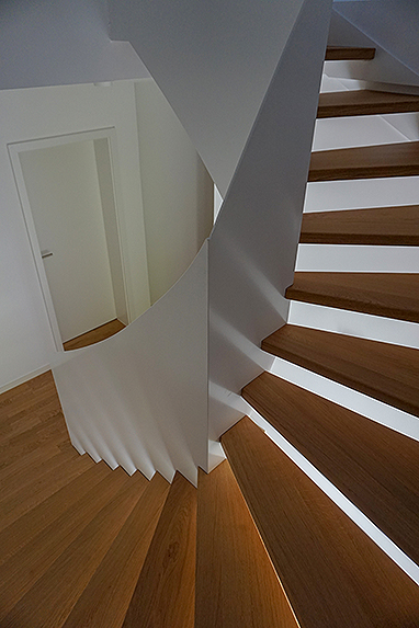 Stahltreppe und Geländer in einem. Stahlblech 10 mm dick, übergehend in Geländer, Oberfläche in weiß lackiert, Stufen in Eiche.