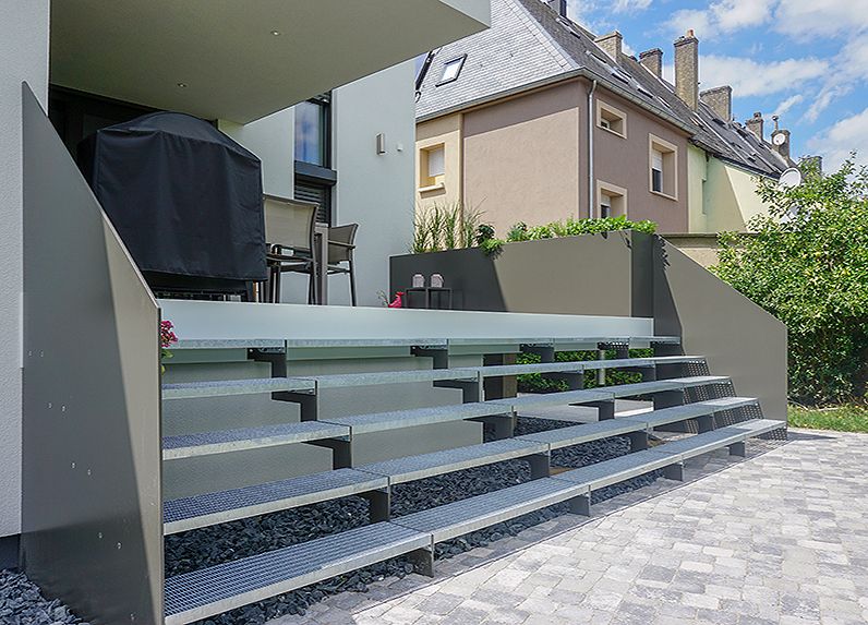 Verzinkte und pulverebschichtete Treppe über die gesamte Breite der Terrasse, Stufen aus Gitterrost, Geländer aus Blech mit integriertem Blumenkasten