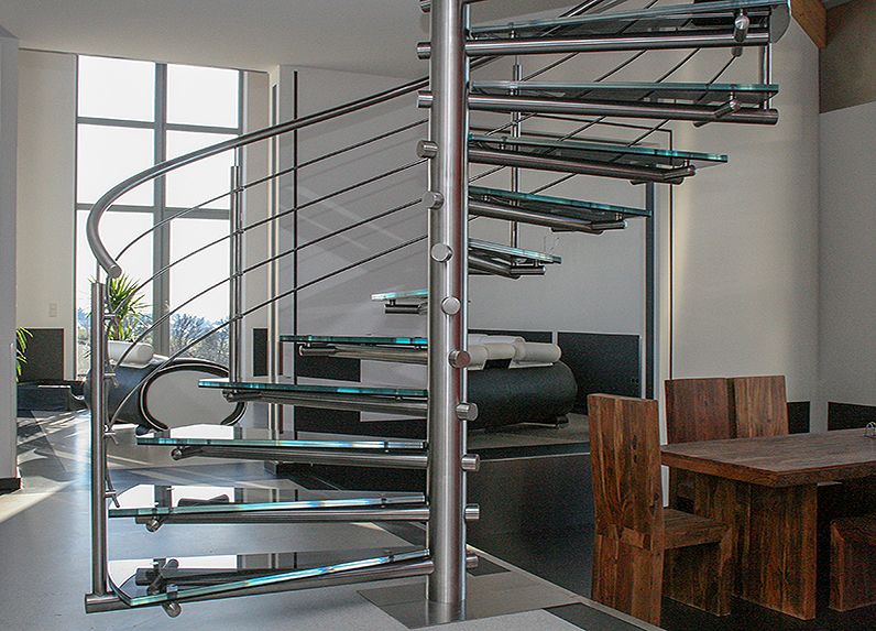 Spindeltreppe bzw. Wendeltreppe aus Edelstahl, Stufen aus Glas (Verbundsicherheitsglas), komplett aus Edelstahl und einem Geländer aus Edelstahl.